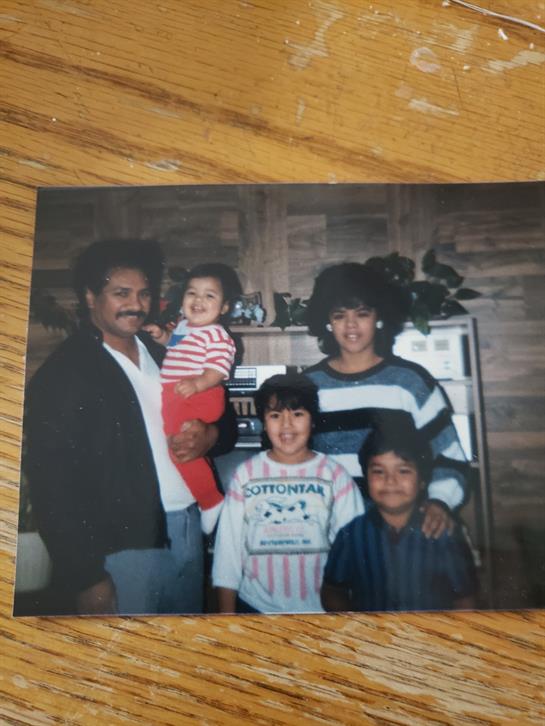 Family members gather in a cozy home setting, smiling and enjoying each other's company.