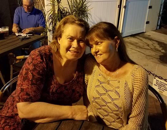 Friends share laughter and conversation at a cozy outdoor cafe, enjoying a warm evening.