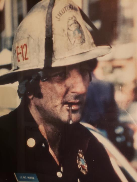 A firefighter is engaged in a rescue operation, surrounded by chaos and urgency in the city.