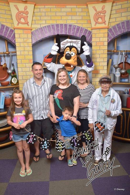 A cheerful family poses with a beloved animated character in a lively dining area.