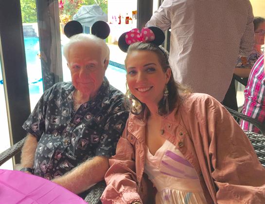 Two friends enjoy a fun themed party with decorative headbands at a vibrant outdoor setting.