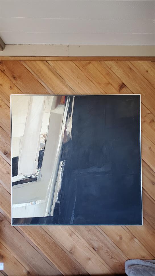 A large mirror reflects a stylish minimalist space with warm wooden flooring, creating depth.