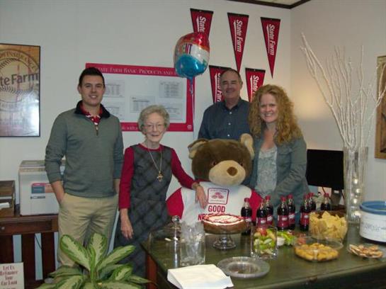 Friends and family gather around a table filled with snacks and drinks for a festive celebration.