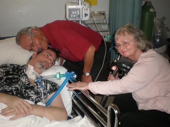 Family members surround a patient in a hospital room, offering comfort and care during recovery.