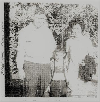 Family members pose happily in a lush garden, capturing a moment of joy and connection.