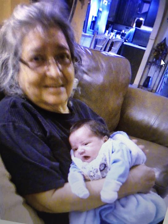 A grandmother hugs her small grandchild on a cozy couch, sharing warmth and joy.