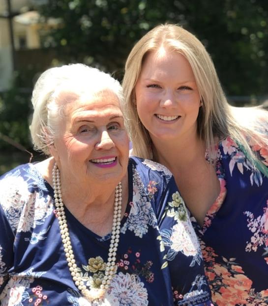 Women enjoy a sunny garden, smiling and celebrating friendship among blooming flowers.