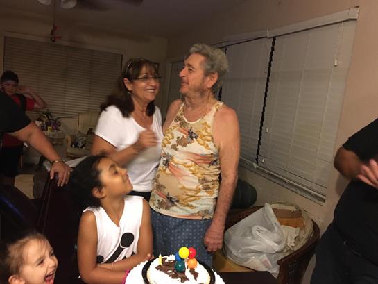 Family members joyfully celebrate a birthday with a cake, laughter, and warm conversations.