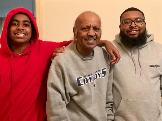 Family members pose closely together, enjoying a casual moment at home in the evening.