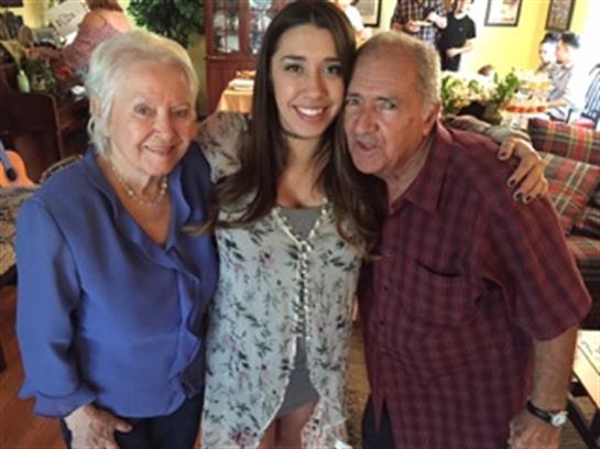 Three family members happily pose in a cozy dining space, showcasing their love and connection.