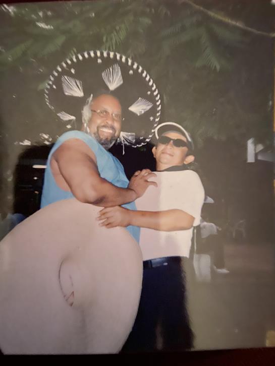 Two friends share laughter and joy while dressed in fun outfits during a lively event.