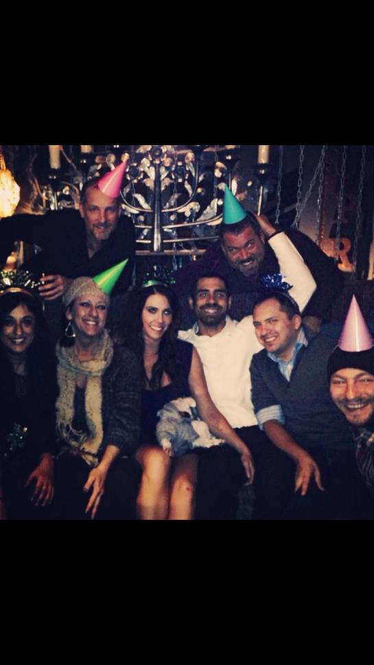 Friends joyfully celebrate together in a festive atmosphere, wearing party hats.