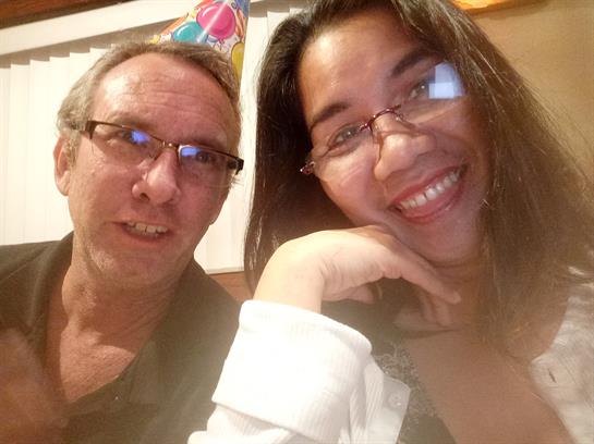 Couple enjoys a fun celebration, wearing party hats and sharing smiles at an evening gathering.