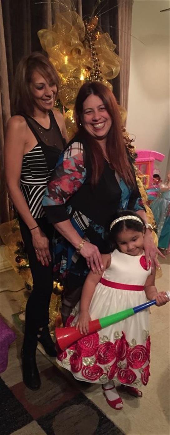 Adults and a child celebrate joyfully, showcasing love and togetherness in a warm home environment.