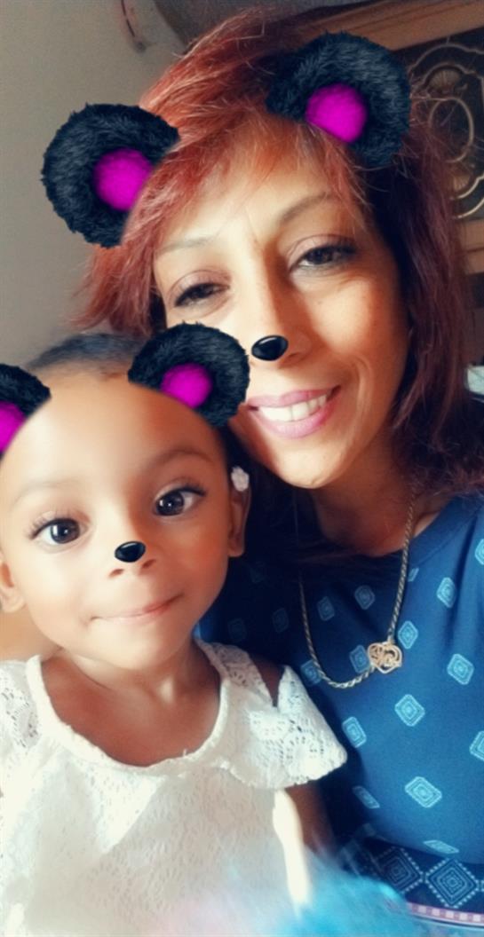 A mother and her daughter share a heartwarming moment together, both smiling playfully with filters.