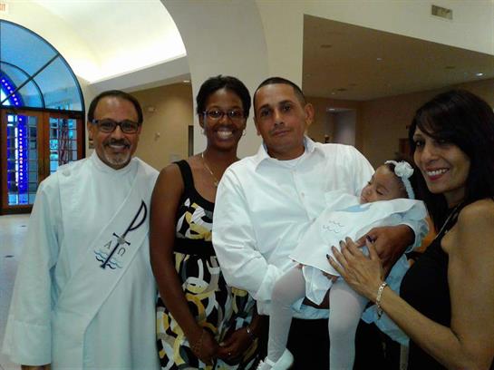 A joyful family gathers together with a baby in a church setting for a special occasion.