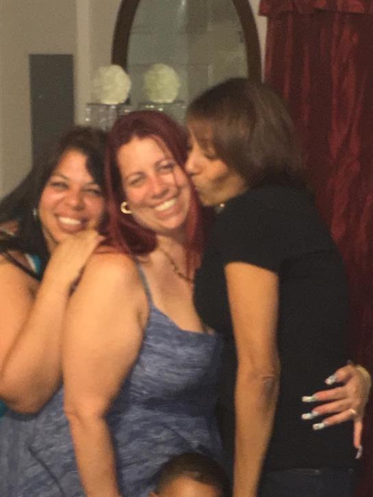 Three friends smile and pose for a cheerful photograph while enjoying each other's company.
