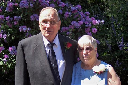 An elderly couple enjoys a joyful spring celebration amid vibrant flowers.
