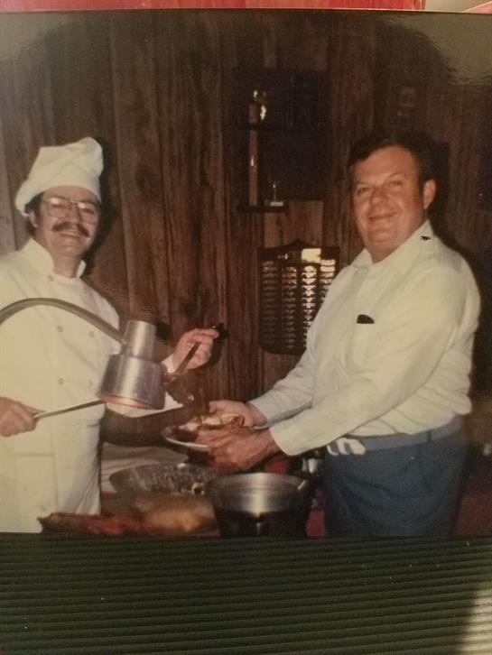 Two chefs collaborate in a vintage kitchen, preparing a delicious meal with enthusiasm.