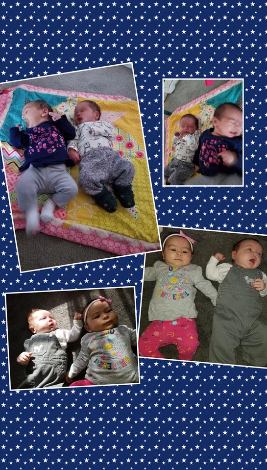 Two adorable twins are playing together on a bright quilt in a living room, enjoying their time.