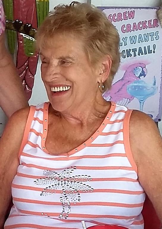 Happy woman enjoys time with friends in a vibrant outdoor setting, sharing laughter and joy.