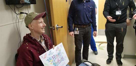 Colleagues gather to celebrate a birthday, sharing smiles and a lively atmosphere.