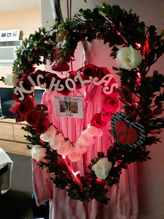 Beautiful floral heart arrangement featuring a name and greeting lights at an event.