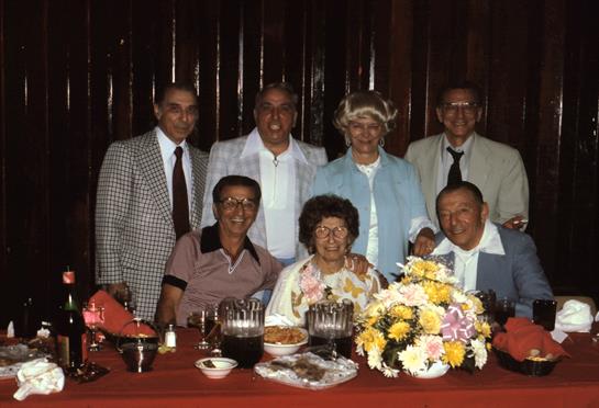 Group of friends and family enjoy a cheerful dinner together in a warmly lit restaurant.