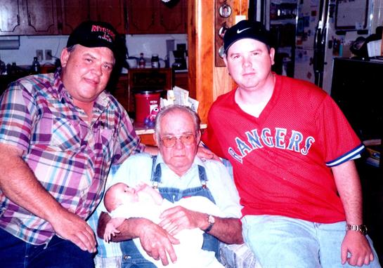 Three men and a baby celebrate family time together in a warm, inviting home environment.