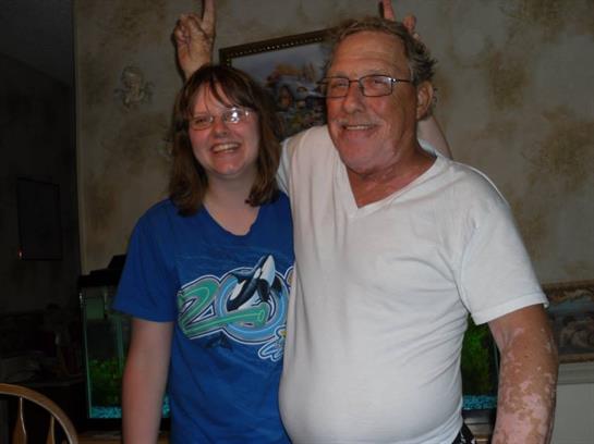 Two friends share a joyful moment, smiling and making playful gestures in a comfortable home.