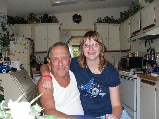 A man and a woman share a joyful moment in a bright kitchen, showcasing smiles and warmth.