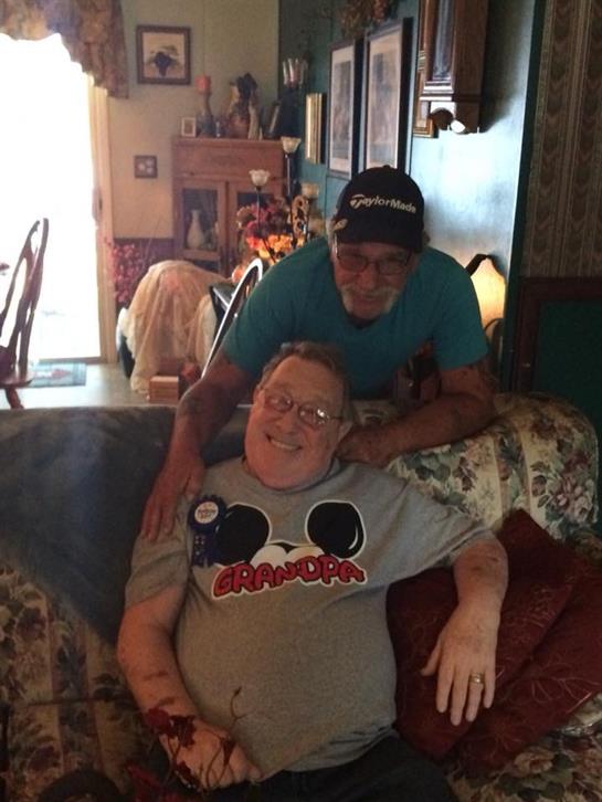 Two men enjoy friendly company seated on a couch in a warm and inviting living room atmosphere.
