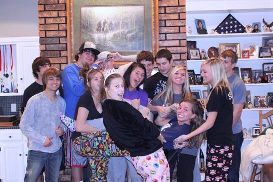Friends gather for a lively evening filled with laughter and playful antics in a warm setting.