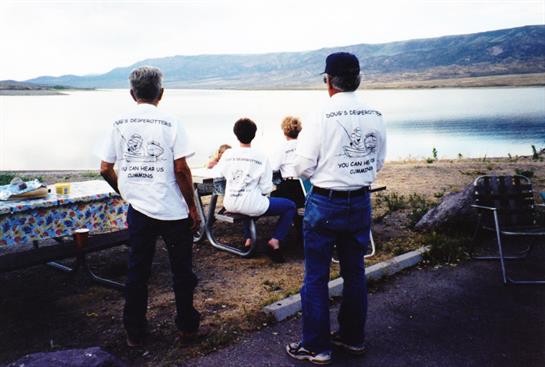 Friends gather by the lake, enjoying the scenic view and camaraderie as the sun sets.