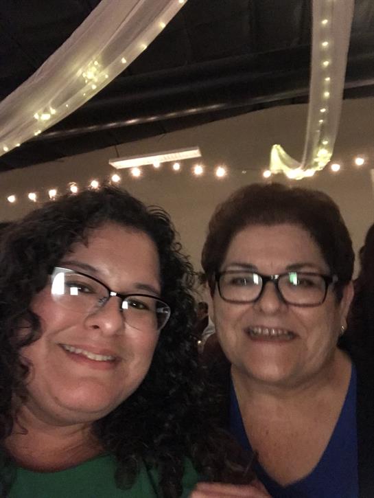 Women enjoy a cheerful moment together surrounded by festive decorations at the event.