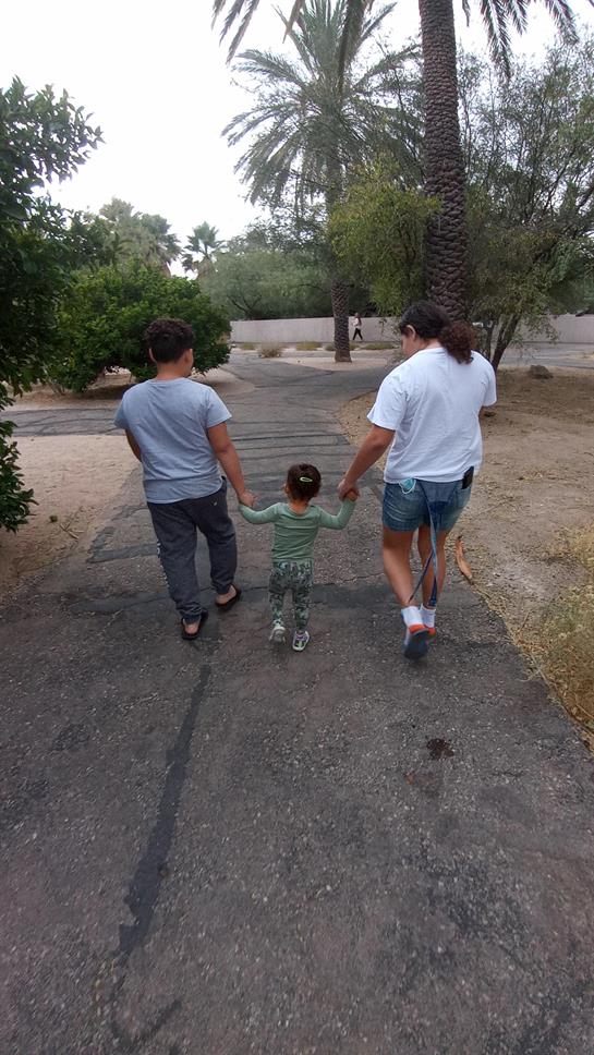 Family enjoys a leisurely walk together on a pathway in a serene park during the afternoon.