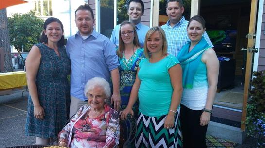 A cheerful family gathers in a backyard during a summer evening.
