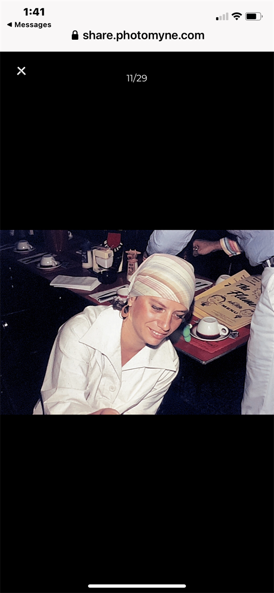 A woman in a chic white outfit mingles with diners, highlighting the restaurant's sociable vibe.