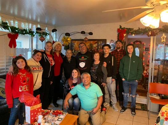 Family and friends gather in a festive living room for a joyful Christmas celebration.