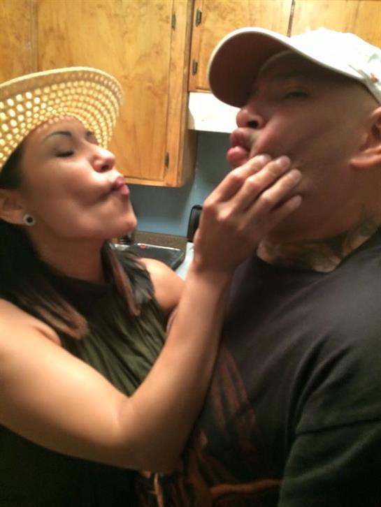 A couple shares a lighthearted moment in their kitchen, showcasing affection and humor.