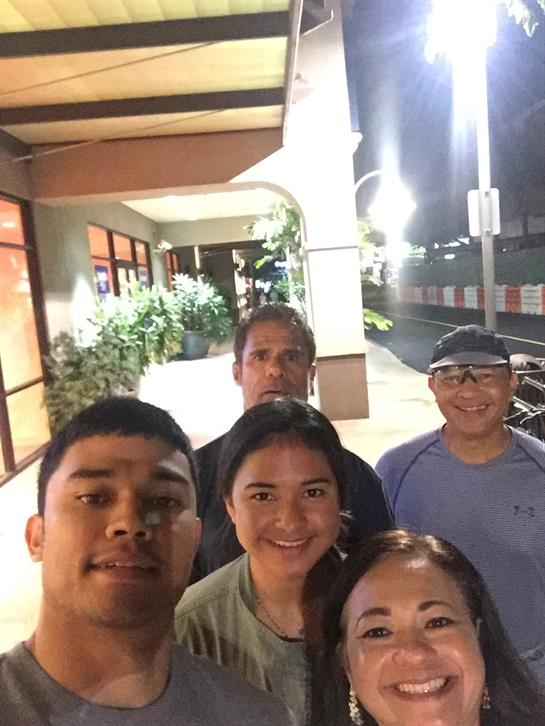 Five friends gather joyfully in an urban setting, enjoying their time together at night.