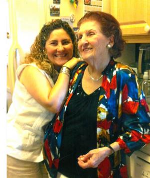 Two family members stand close together, smiling warmly in a vibrant kitchen setting.