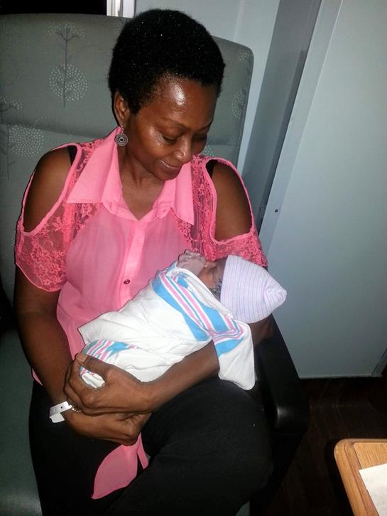 A mother lovingly holds her newborn baby wrapped in a soft blanket.