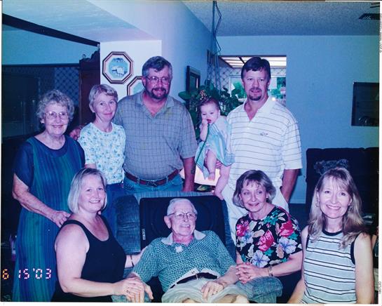 Family members pose together in a living room to celebrate a milestone moment.