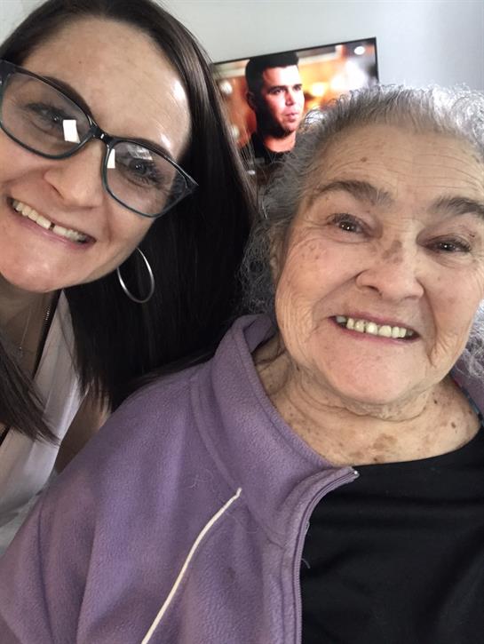 Grandmother and granddaughter share smiles during a warm family gathering in a living room.