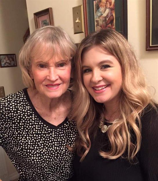 Two women share smiles while posing together in a cozy, welcoming indoor space filled with memories.