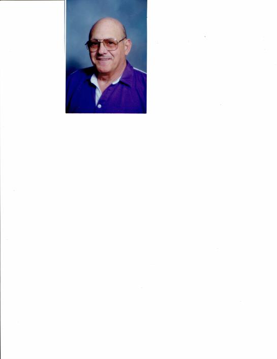 A cheerful elderly man dressed in purple sits comfortably, exuding warmth and friendliness.