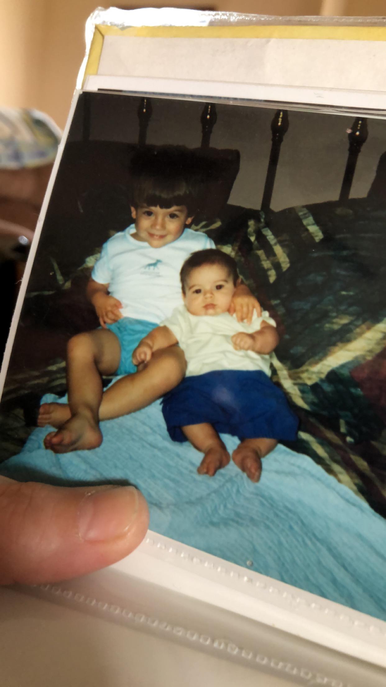 A boy and girl sitting on a bed