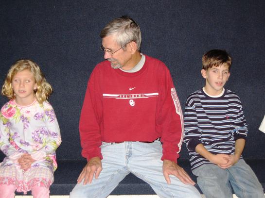 Three family members share a joyful moment indoors, showcasing their close connection.