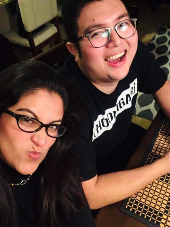 Two friends pose playfully at a table, showcasing their camaraderie and enjoyment in a cozy space.